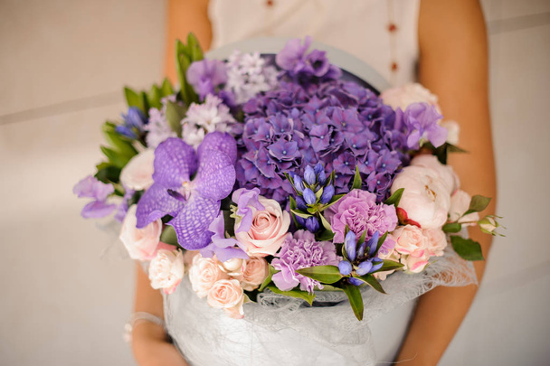 Hands with a lovely purple composition of flowers - Φωτογραφία, εικόνα