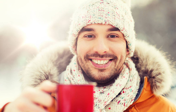 happy man with tea cup outdoors in winter - Foto, imagen
