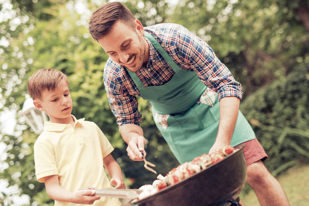 Famiglia che fa barbecue nella giornata di sole
 - Foto, immagini