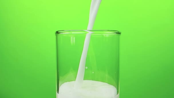 fresh white milk pouring into drinking glass on chroma key green screen background, shooting with slow motion, diet and healthy nutrition  - Video, Çekim