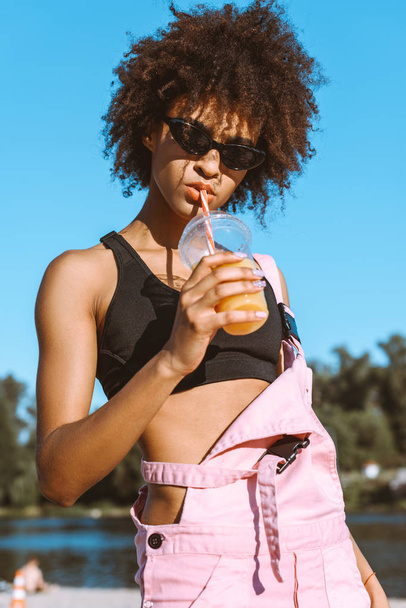 african-american woman drinking juice - Fotó, kép