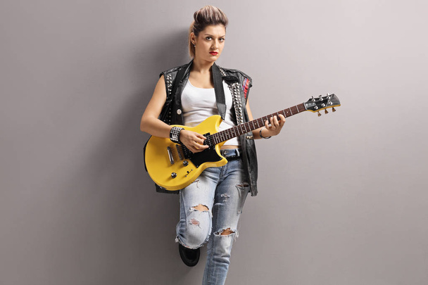 Punk girl playing an electric guitar - Фото, зображення