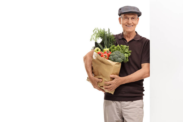 man holding a paper bag filled with groceries - Foto, imagen