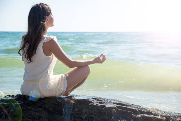 Woman meditating at the sea - Photo, image