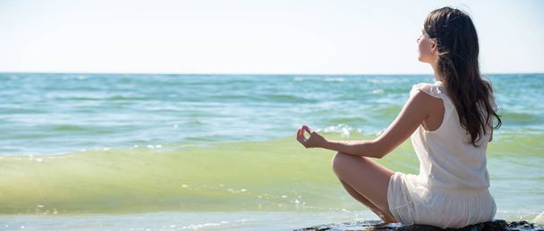 Woman meditating at the sea - Photo, Image