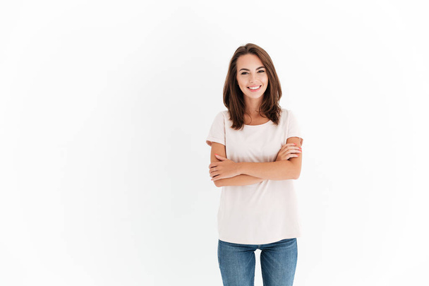 Smiling brunette woman with crossed arms looking at the camera - Foto, afbeelding