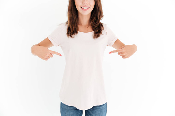 Cropped image of smiling woman pointing on her body - Фото, зображення