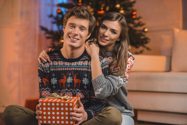 woman hugging boyfriend with christmas gift - Фото, изображение