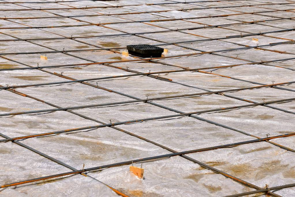 Varetas de reforço e plástico sobre um projeto de piso de concreto
 - Foto, Imagem