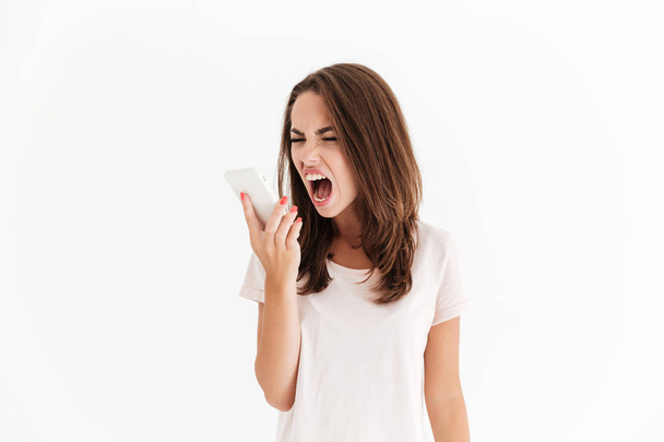 Brunette woman screaming on her smartphone - Foto, Imagem