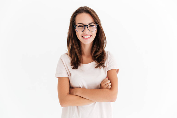 Joyful brunette woman in eyeglasses posing with crossed arms - Фото, изображение