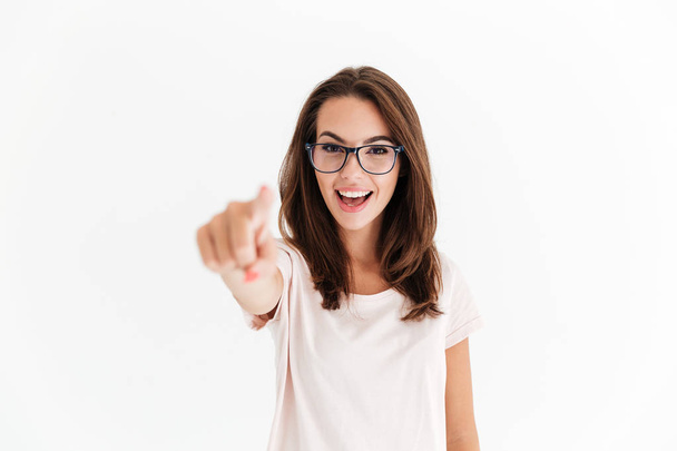 Happy brunette woman in eyeglasses pointing at the camera - 写真・画像