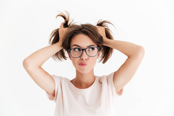 Pensive pretty woman in eyeglasses holding hair and looking away - Zdjęcie, obraz