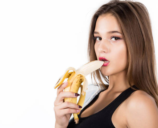 Young beautiful woman eating banana on white background - Fotoğraf, Görsel