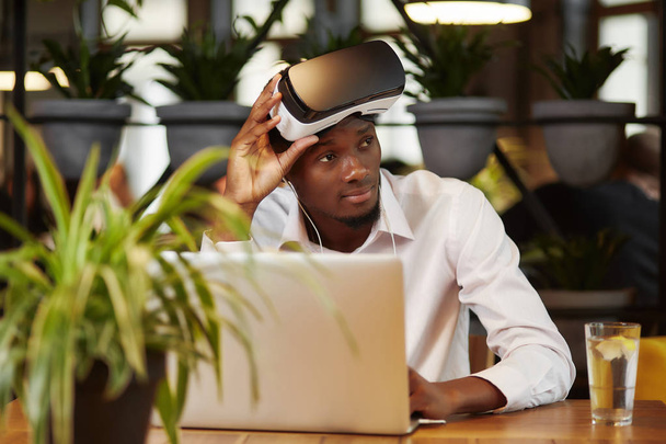 African man in glasses of virtual reality on head. - 写真・画像
