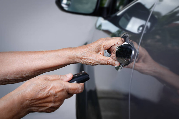  Ältere Frau gibt Autoschlüssel an Alarmanlage ab - Foto, Bild