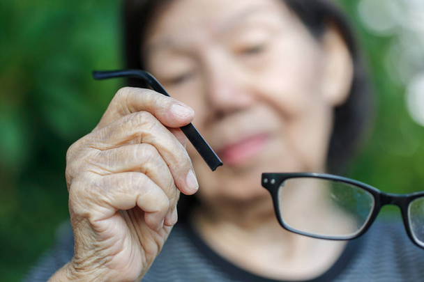 personnes âgées asiatique femme réparation cassé lunettes
 - Photo, image