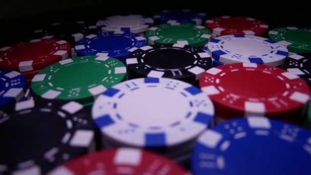 Mnoho roztočení Poker žetony na stole v temnotě - Záběry, video