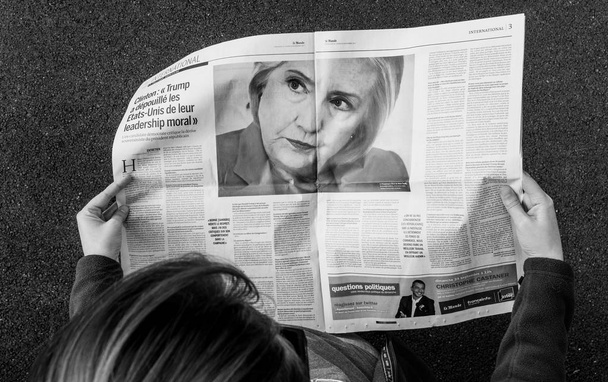 Woman reading newspaper about Hillary Clinton - Фото, изображение