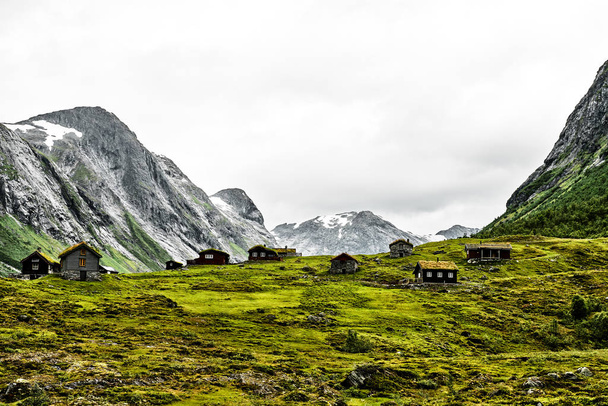 Landschaft und Natur in den Bergen Norwegens mit Grasdachhäusern im Vordergrund - Foto, Bild