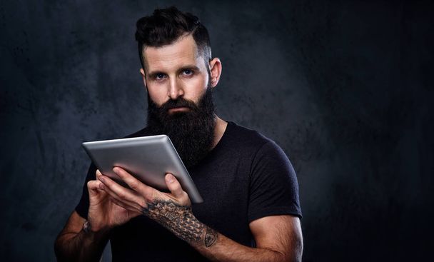 Bearded man using silver tablet  - Foto, Imagen