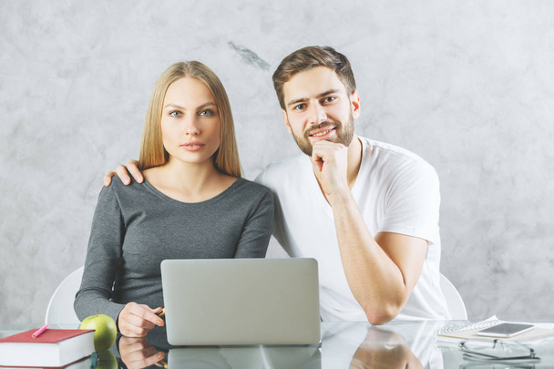 Attractive couple at desk with laptop  - Foto, Bild