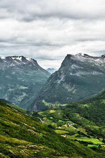 Detailní pohled na hory v západní Norsko s malé vesnice a města v dolní části údolí a vrcholy pokryté sněhem - Fotografie, Obrázek