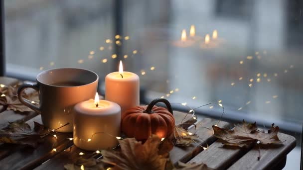 cup of coffee, pumpkin and candles on table - Záběry, video