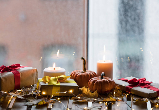 calabazas, regalos y velas con hojas de arce
 - Foto, Imagen