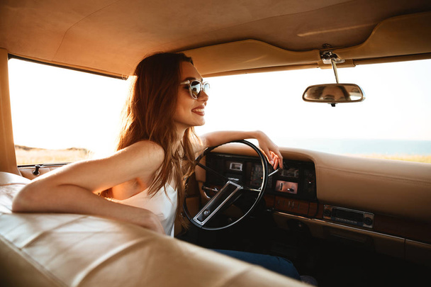 Image from car of Smiling brunette woman in sunglasses - Фото, зображення