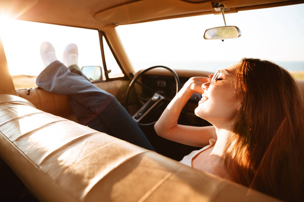 Image from car of pleased brunette woman lying on seat - Foto, Bild