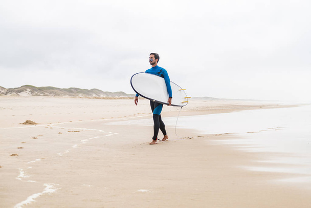 Young male surfer wearing wetsuit - 写真・画像