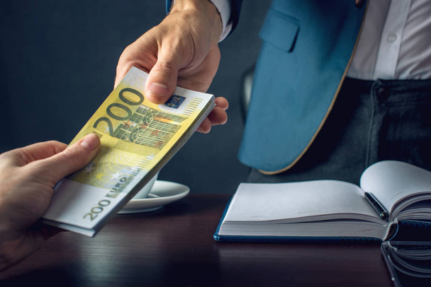 Podnikatel muž v obleku bere do rukou peníze. Úplatek v podobě bankovek eura. Pojem korupce a úplatkářství - Fotografie, Obrázek
