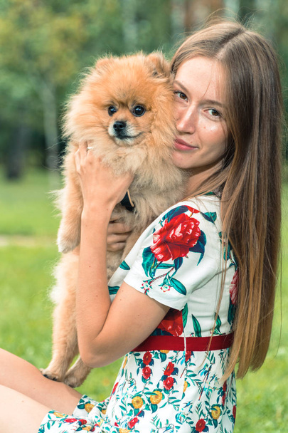 Una ragazza cammina con un parco con un cane. Spitz alla Pomerania
 - Foto, immagini