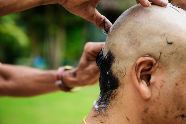 Afeitarse el cabello para la ceremonia de ordenación budista
 - Foto, Imagen