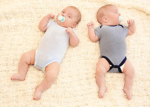 Cute little babies lying on bed at home - Foto, afbeelding