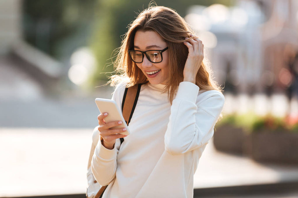 Surprised happy brunette woman in eyeglasses and autumn clothes - 写真・画像