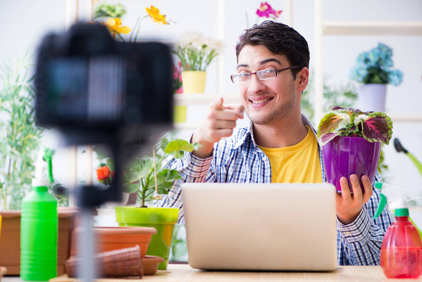 Чоловік квітка садівник відеоблогер знімає відео на камеру
 - Фото, зображення