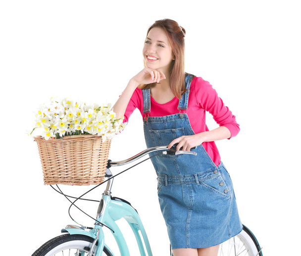 Young girl with bicycle and basket of flowers - Фото, изображение