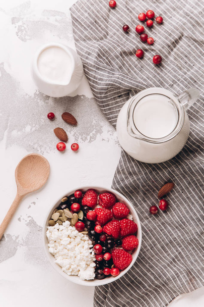 Cottage cheese with berries and nuts for breakfast - Foto, afbeelding