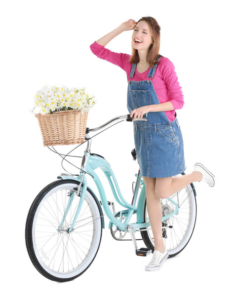 Young girl with bicycle and basket of flowers - Valokuva, kuva
