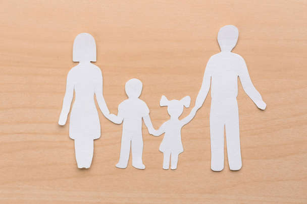 Papíru siluetu rodiny na dřevěné pozadí. Životní pojištění koncept - Fotografie, Obrázek
