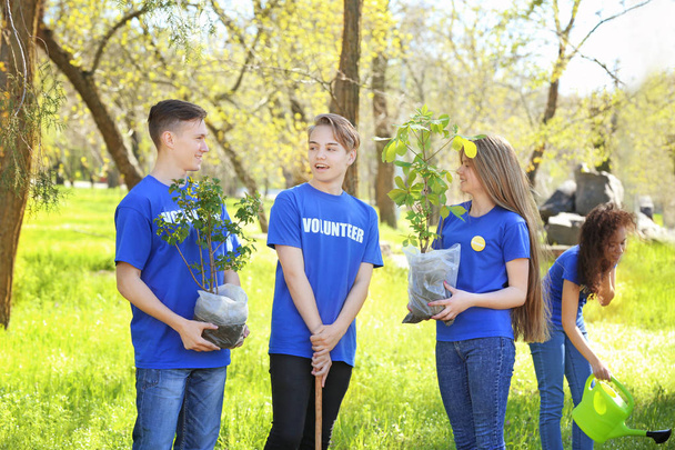 Group of young volunteers in park on sunny day - Fotó, kép
