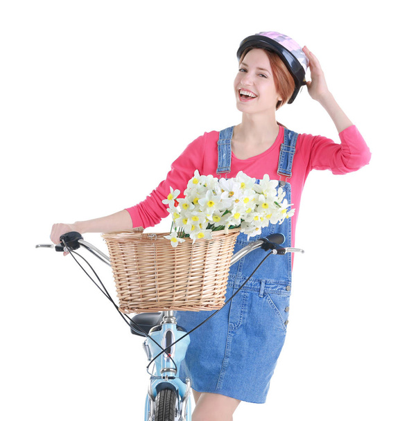 Young girl with bicycle and basket of flowers - Foto, afbeelding