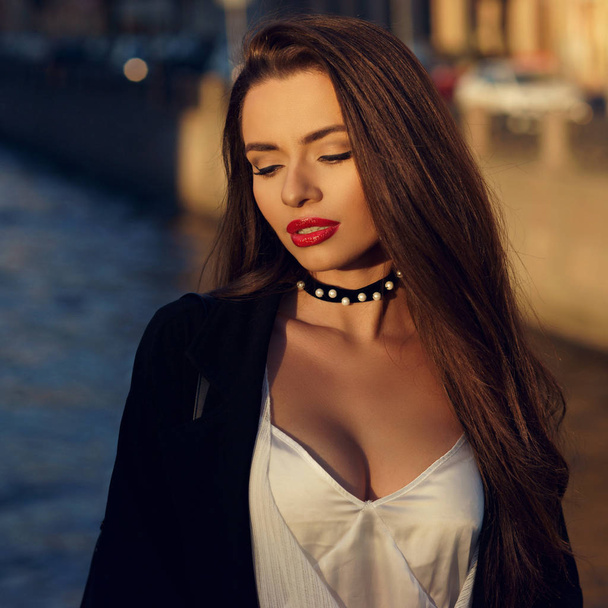 Attractive brunette woman posing against river on background - Photo, Image