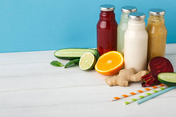 Assortment of detox smoothies in glass bottles on wall background. - Photo, Image