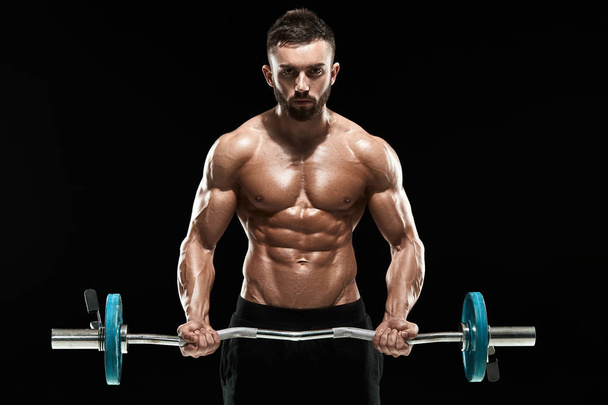 muskulöser Mann stemmt Gewichte vor dunklem Hintergrund - Foto, Bild