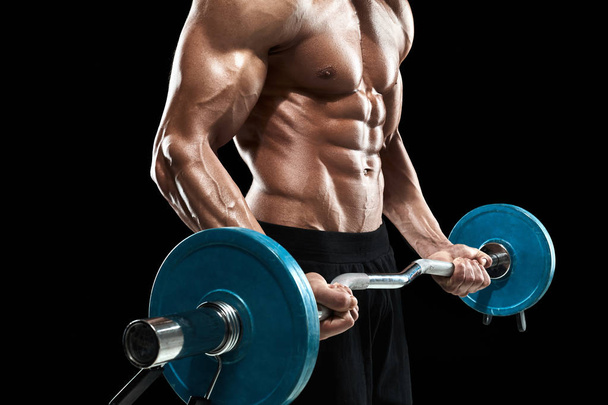 muscular man lifting weights over dark background - Photo, image