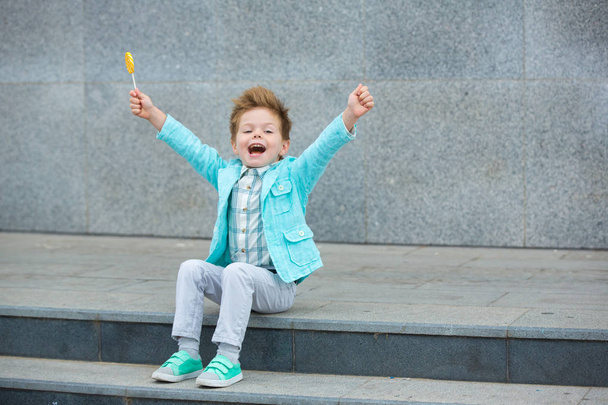 Fashion kid with lollipop near gray wall - Φωτογραφία, εικόνα
