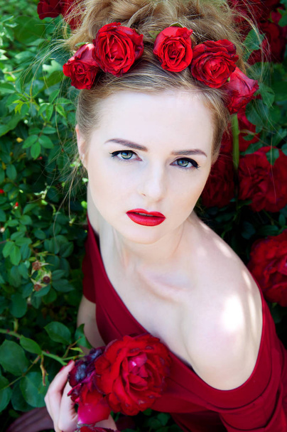 裸の肩と赤いバラの深紅色の赤いドレスの女性のヴァンプ - 写真・画像